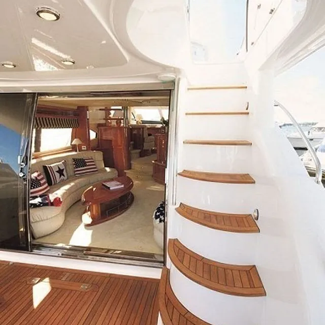 Trapp i treverk fører opp fra bakdekk til øvre nivå med innsyn til salong.