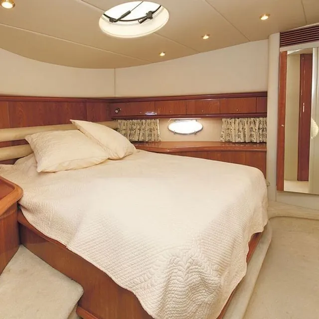 Lugar med dobbeltseng, speil, skap og koøye med gardiner i klassisk stil.