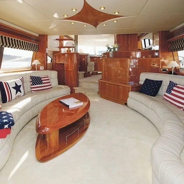 Romslig salong med to store sofaer, bord og maritim innredning med utsikt.