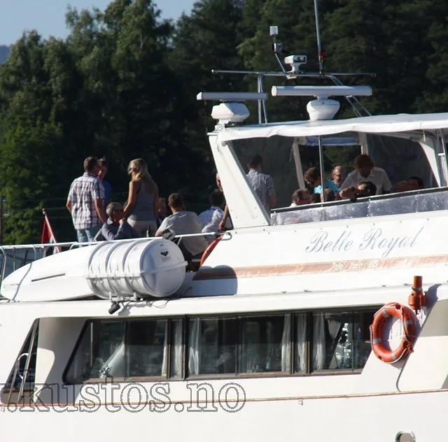 Gruppe mennesker på øverste dekk av båten Belle Royal under tur på sjøen.