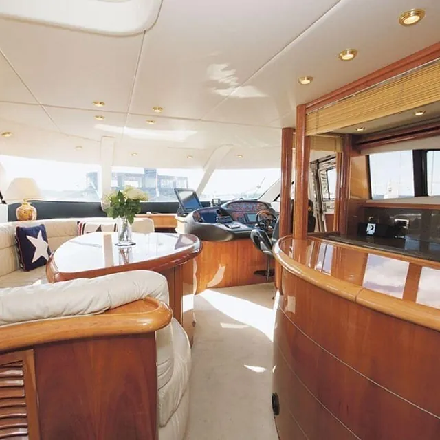 Oversikt fra salong mot førerposisjon, buet kjøkkenbenk og styrekonsoll.