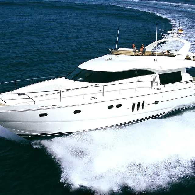 Stor motorbåt i fart over åpent hav med skumsprøyt og passasjerer på øverste dekk